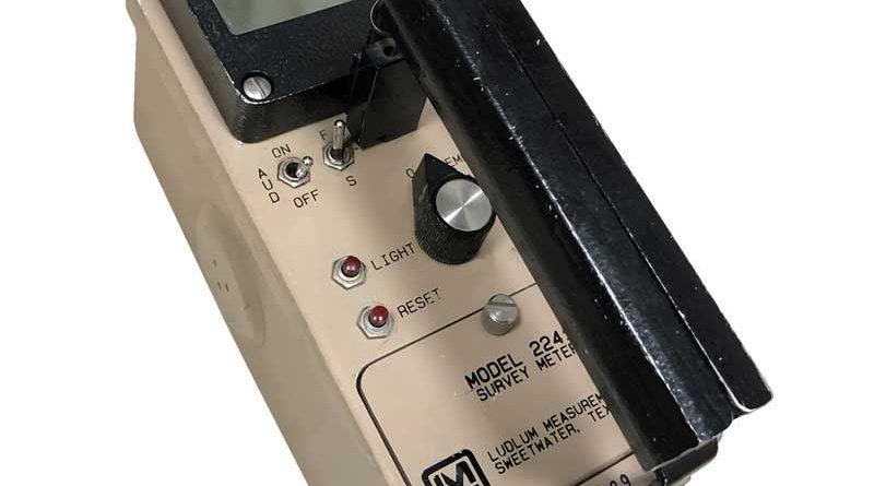 Vintage handheld light meter with analog controls and a solar cell.