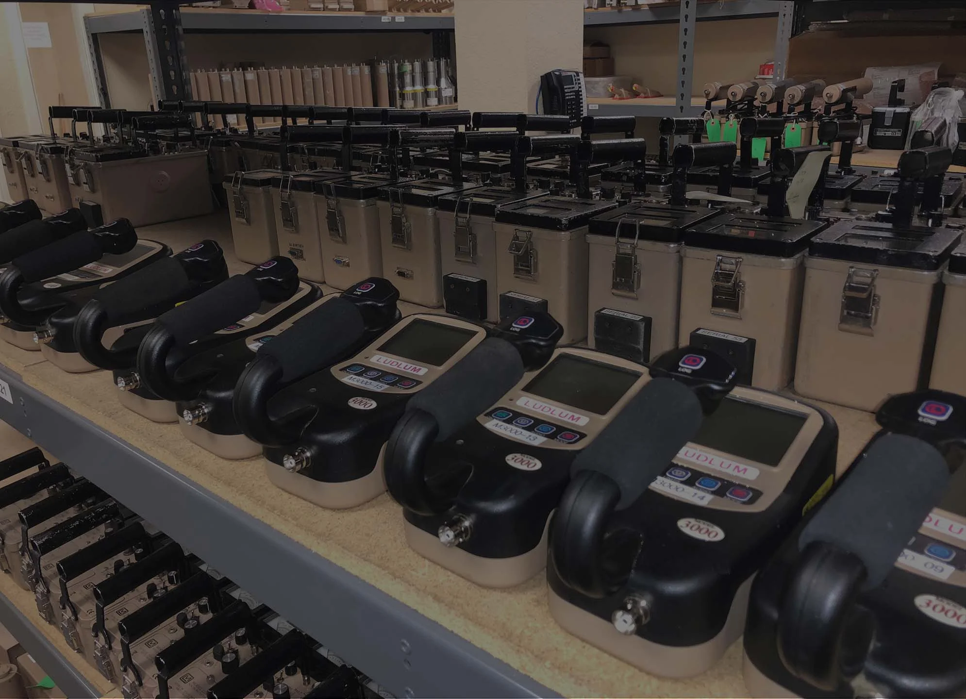 Rows of electronic devices connected and organized on shelves in a lab.