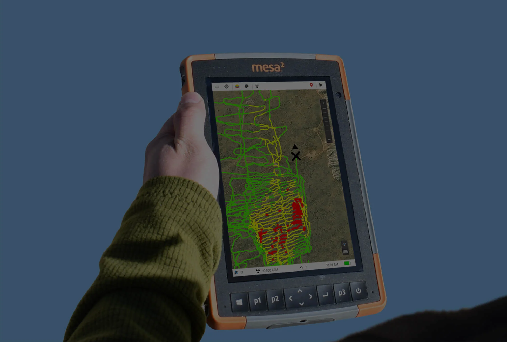 Hand holding a rugged tablet displaying a colorful terrain map.